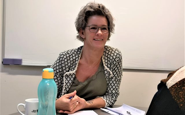 Dicte Jespersen sidder ved bord med papirer foran sig og kigger på en af de andre deltagere på coaching-forløbet ved Dania i Skive