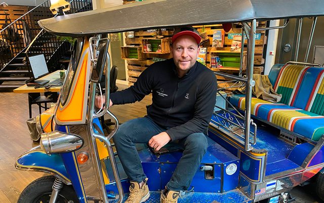 Dennis Kjeldsen sidder på en tuktuk i forhallen til Jysk Rejsebureau, hvor han arbejder.