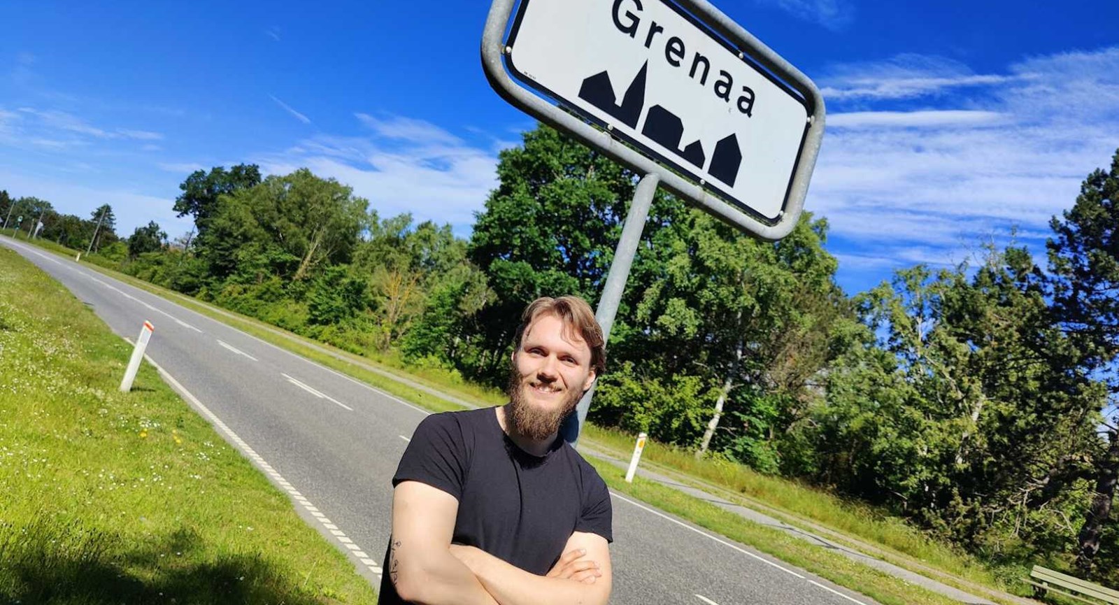 24-årige Andreas Hendriksen læner sig op ad byskiltet til Grenaa, hvor han er flyttet til for at læse til spiludvikler på Erhvervsakademi Dania