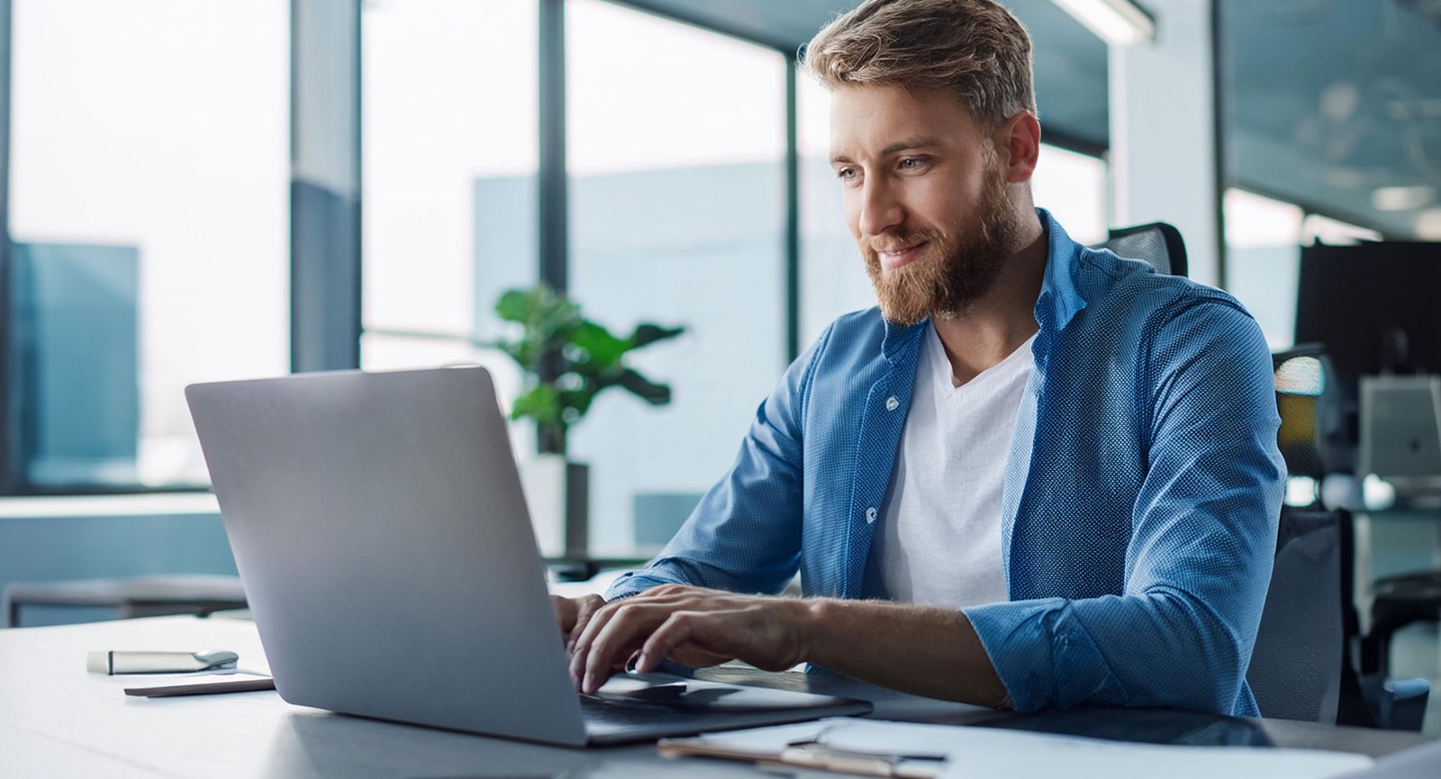 mander der sidder ved en computer