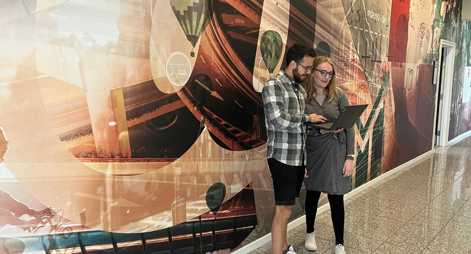 To studerende fra Erhvervsakademi Dania står på gangen og snakker