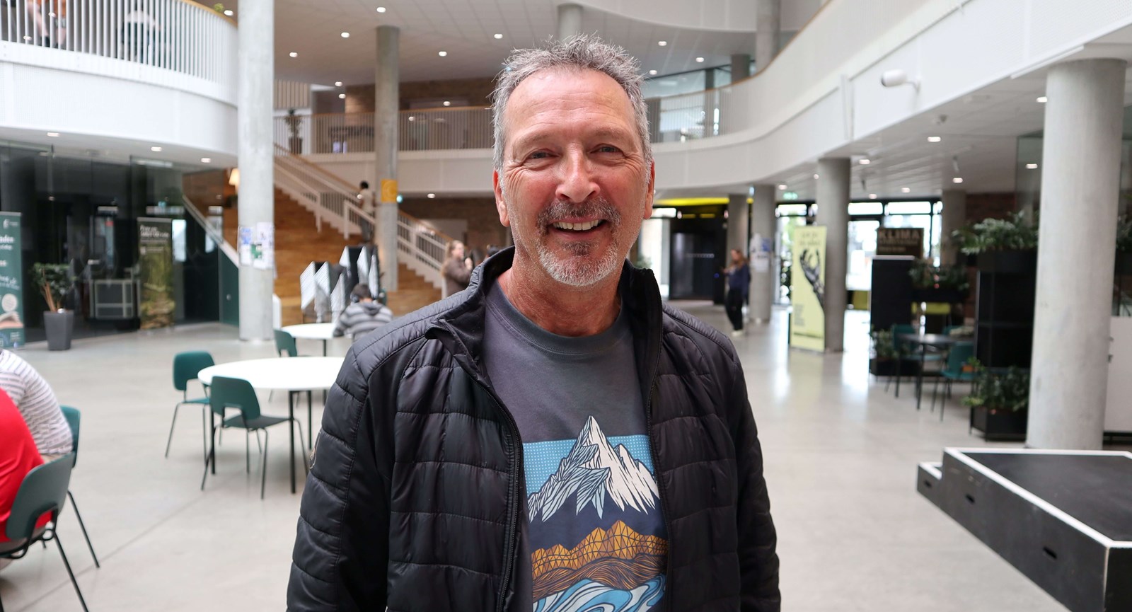 Kim Mandor Faarkrog Christensen står i kantinen på campus Horsens med et smil