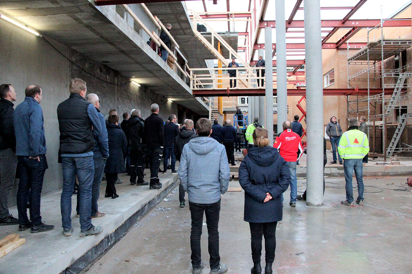 Medarbejdere og håndværkere lytter til taler under rejsegildet på Dania