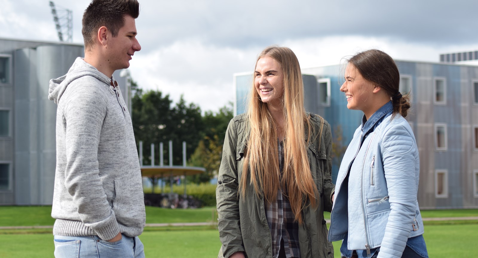 Studerende fra udlandet smiler til hinanden og bidrager til et internationalt studiemiljø hos Erhvervsakademi Dania