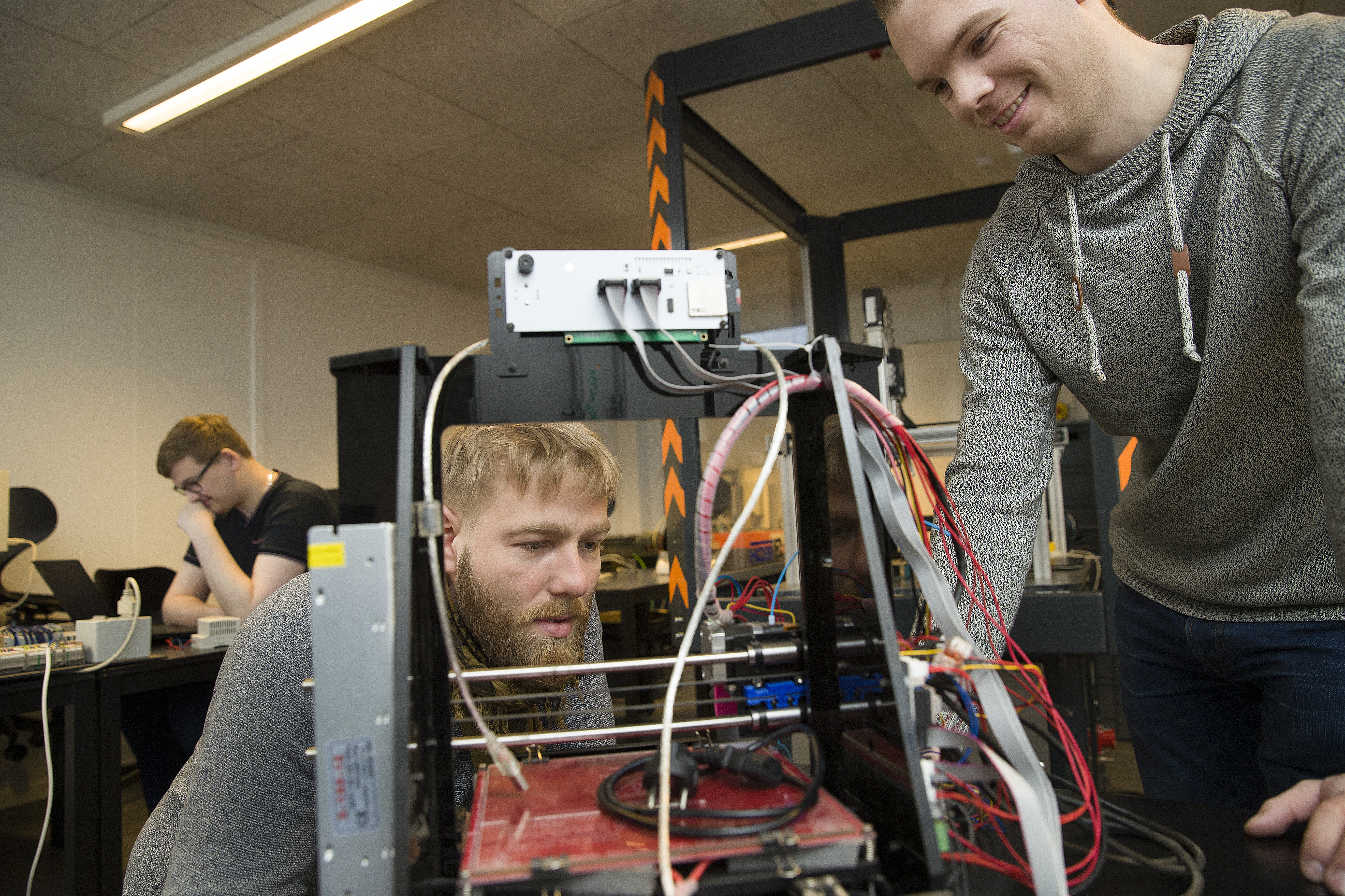 Automationsteknolog-studerende kigger fascinerende på en robot