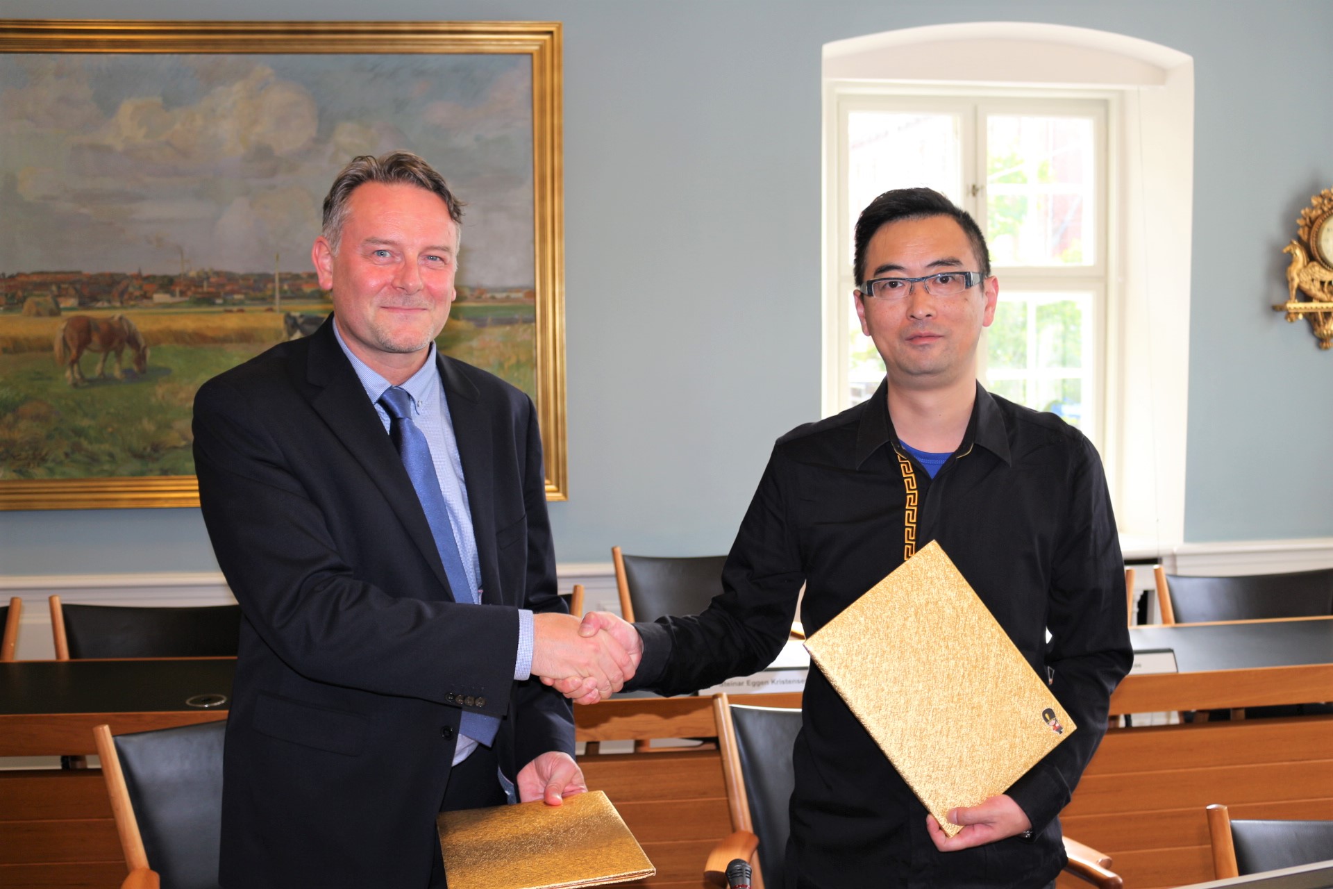 Paul Aspinal giver hånd til kineser, der har underskrevet aftale med Dania