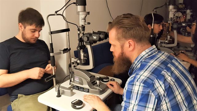 De to studerende Mark og Jacob ved noget af optometristernes udstyr på klinikken