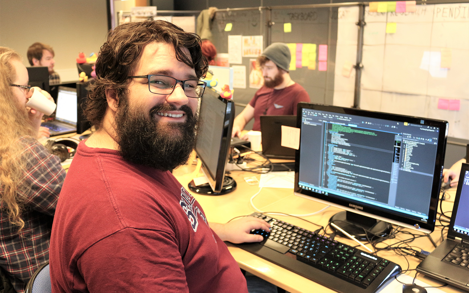 Tue foran sin computer ifærd med at programmere - og smile til kameraet