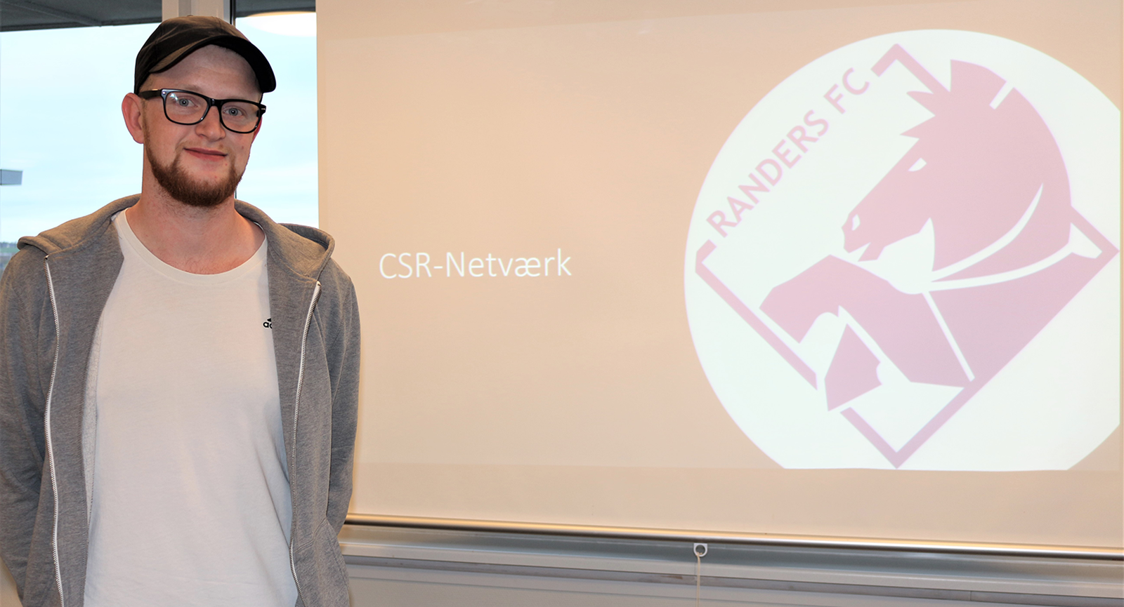 Jonas foran skærm med teksten CSR-netværk og logo fra Randers FC