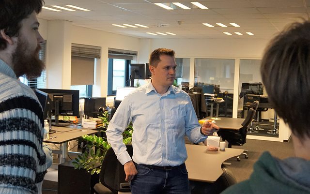 Niels Thorsen peger mod skærm til teammøde med udviklerne i Freeway