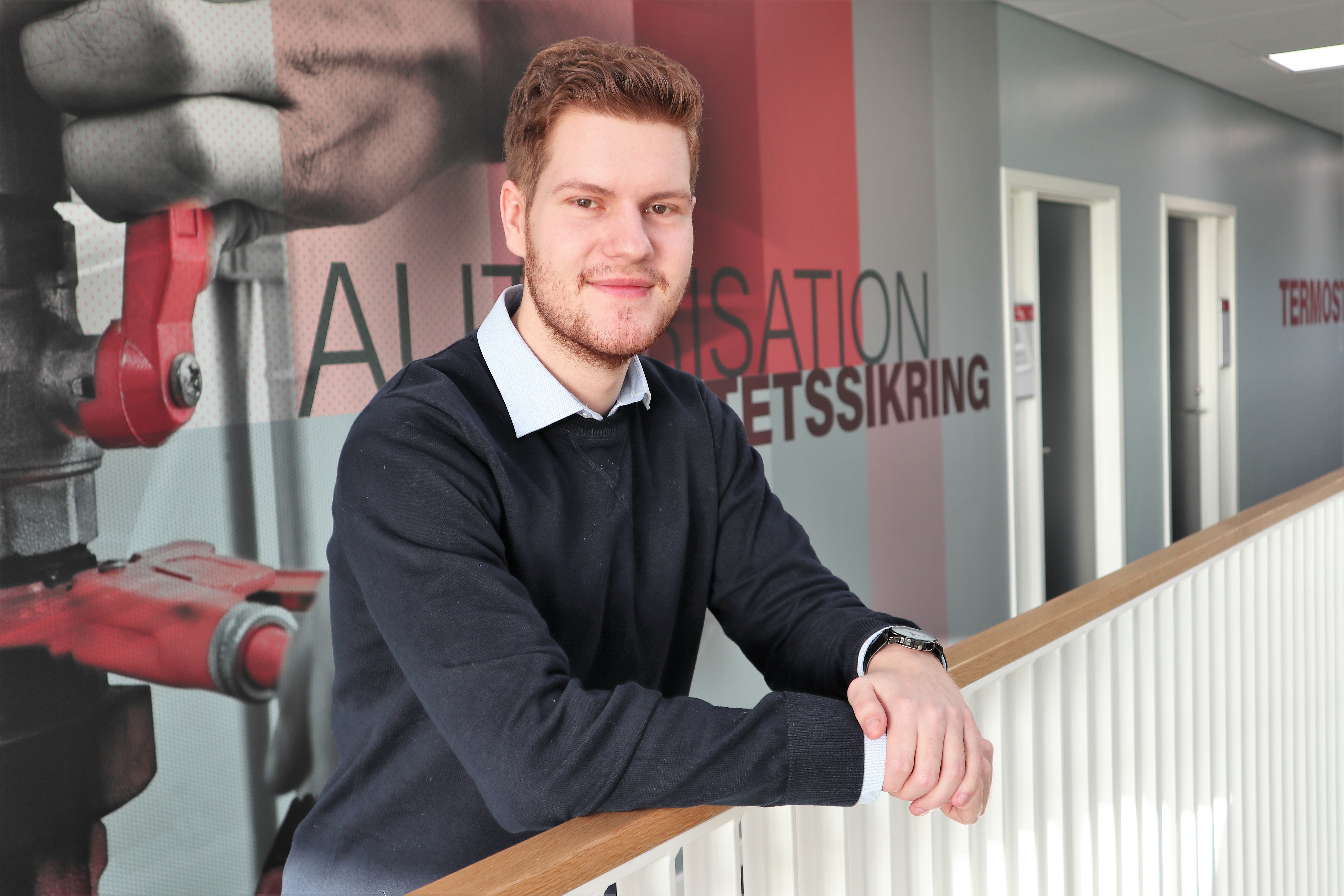 Produktionsteknolog-studerende Morten står ved gelænder på gangen på campus i Randers