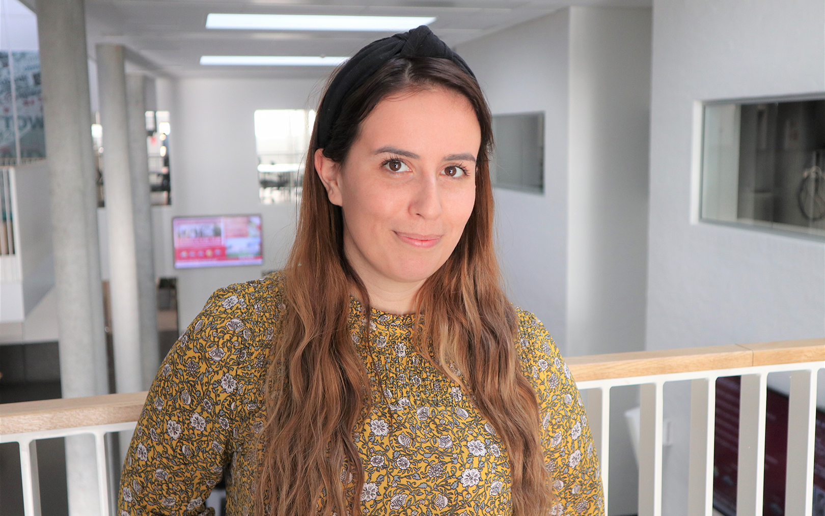 Emilie i blomstret højhalet kjole på repos i Randers med kantinen i baggrunden