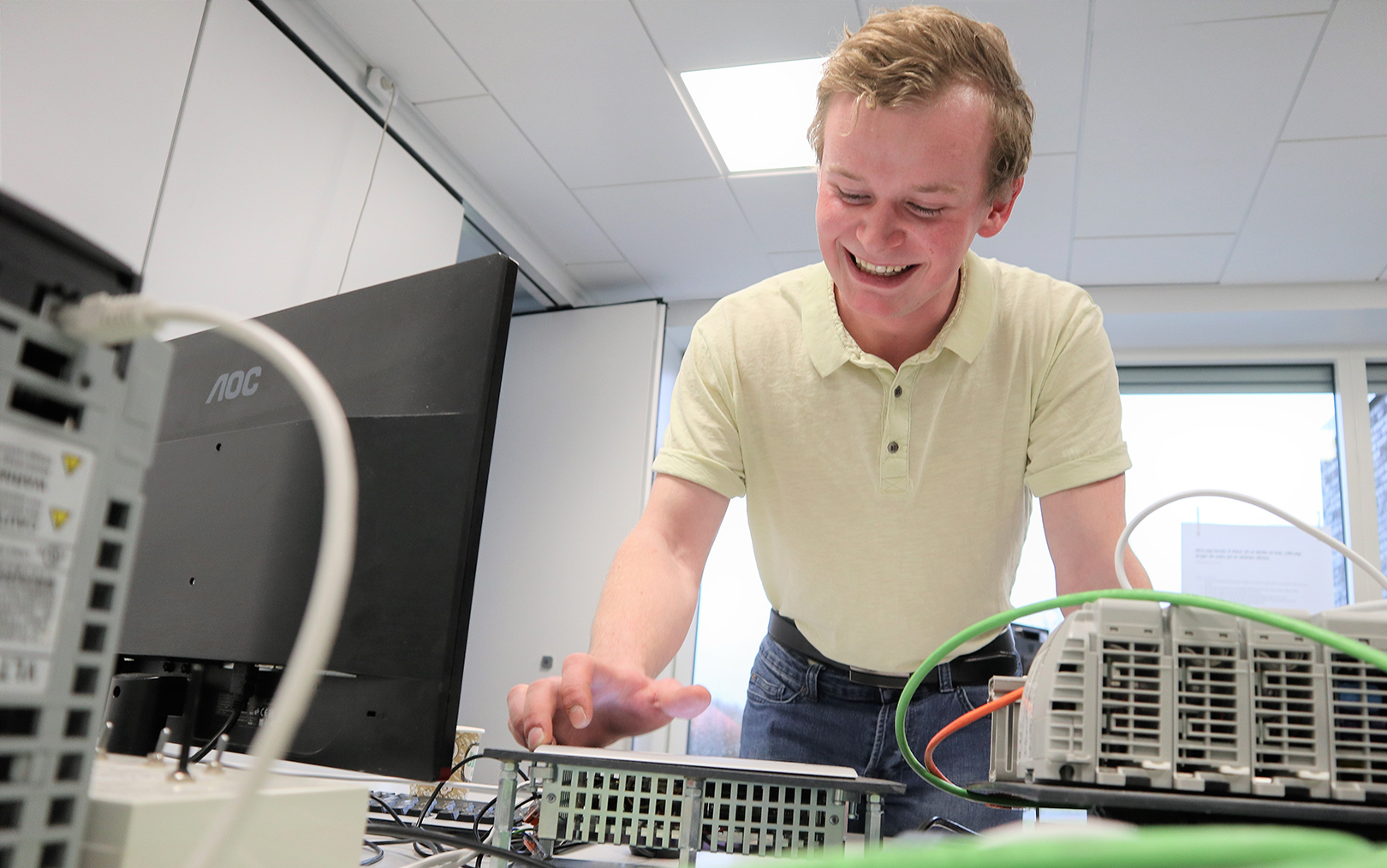 Patrick trykker på panel til styring af PLC-udstyr liggende foran sig