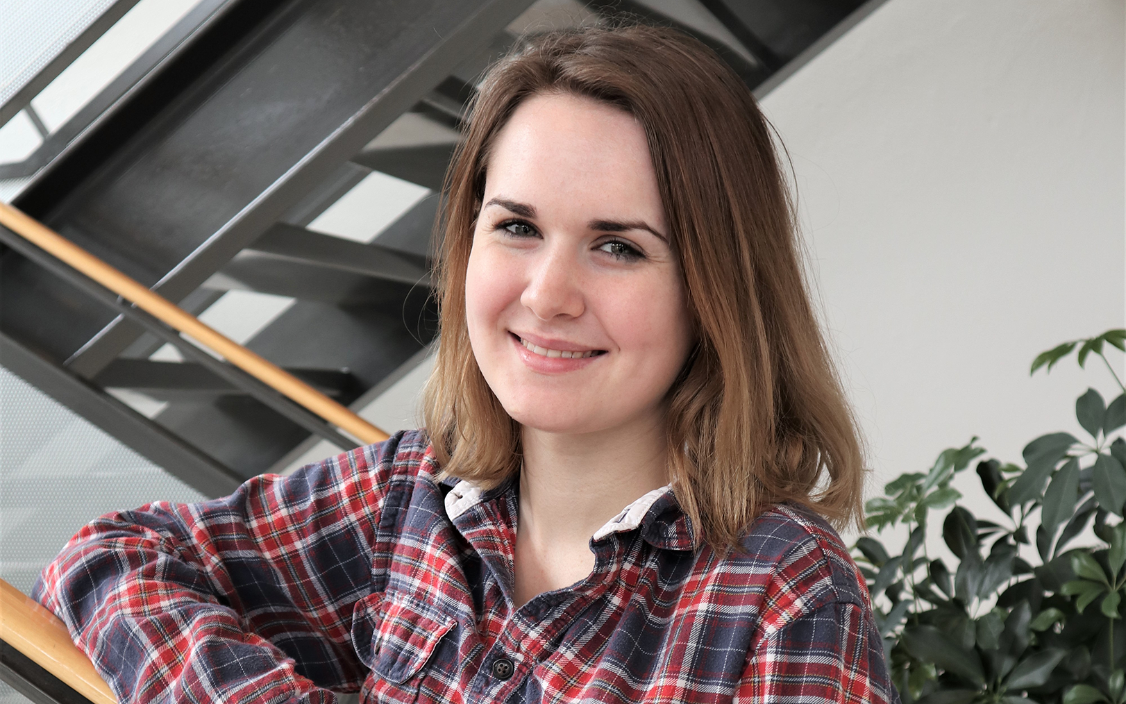 Smilende Sarah ved trappe på campus Silkeborg, hvor hun læser til finansøkonom