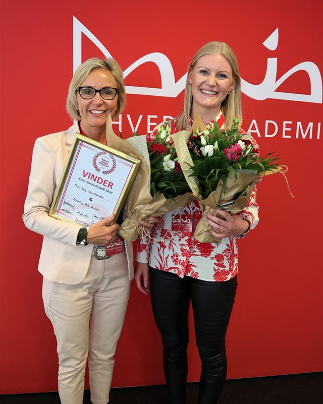 Inge og Mie smiler med blomster og diplom i hænderne