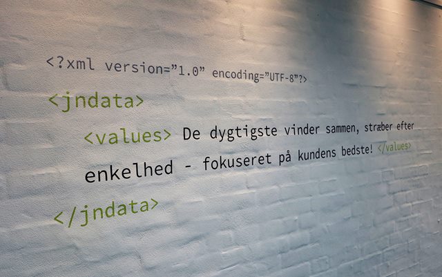 JN Datas værdier skrevet på væggen som en kode: De dygtigste vinder sammen, stræber efter enkelthed - fokuseret på kundens bedste