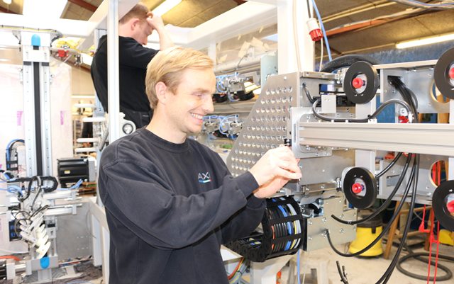 Produktionsteknolog Morten skruer i maskine