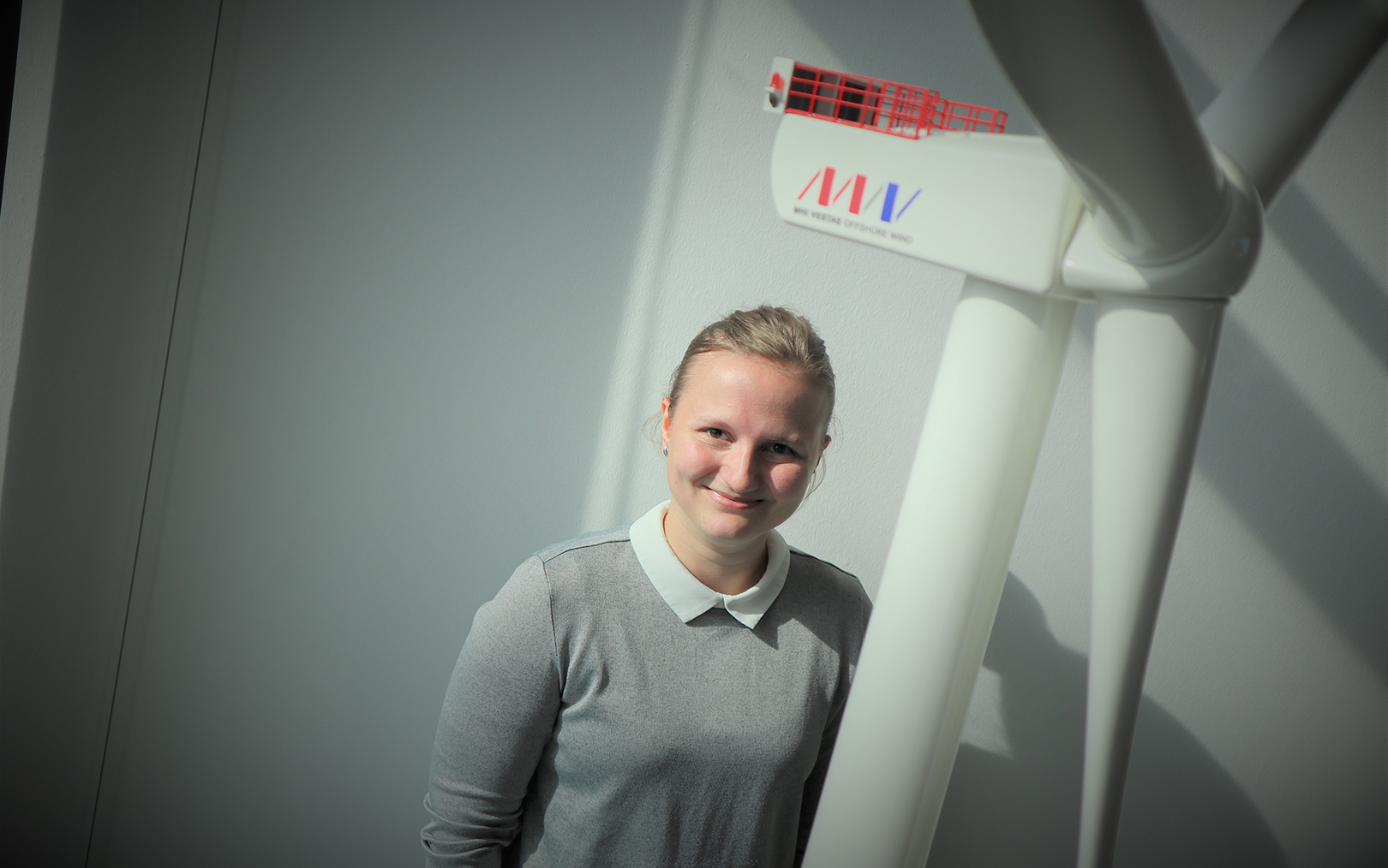 Isabella Kjær Jensen står ved siden af større model af Vestas vindmølle