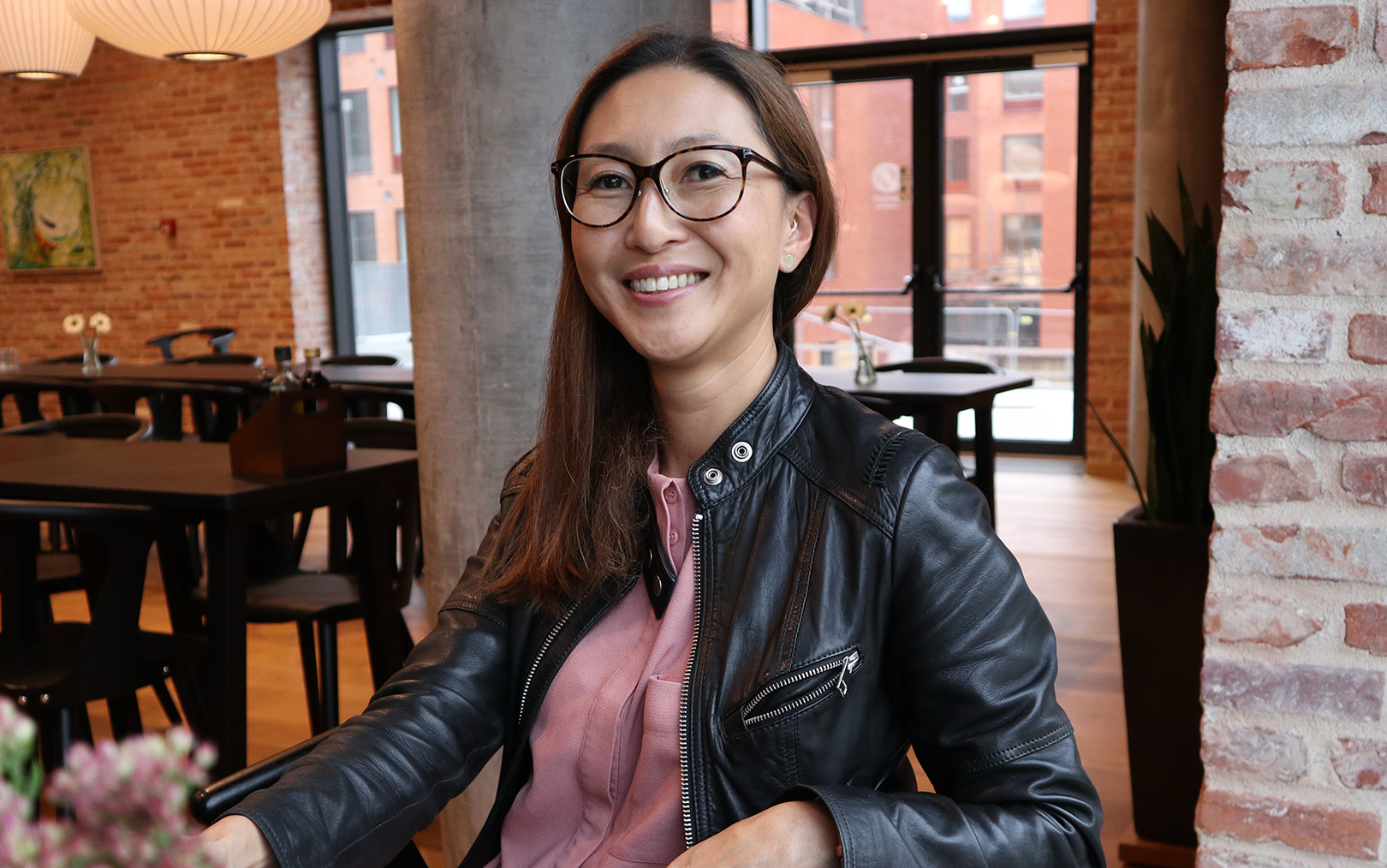 Handelsøkonomen Mia smiler til dig, mens hun sidder tæt på mursensvæg 