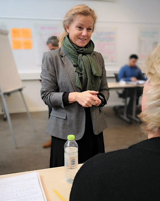 Liselotte Christensen snakker med en kursist og underviser på forløbet i coaching på Erhvervsakademi Dania i Skive