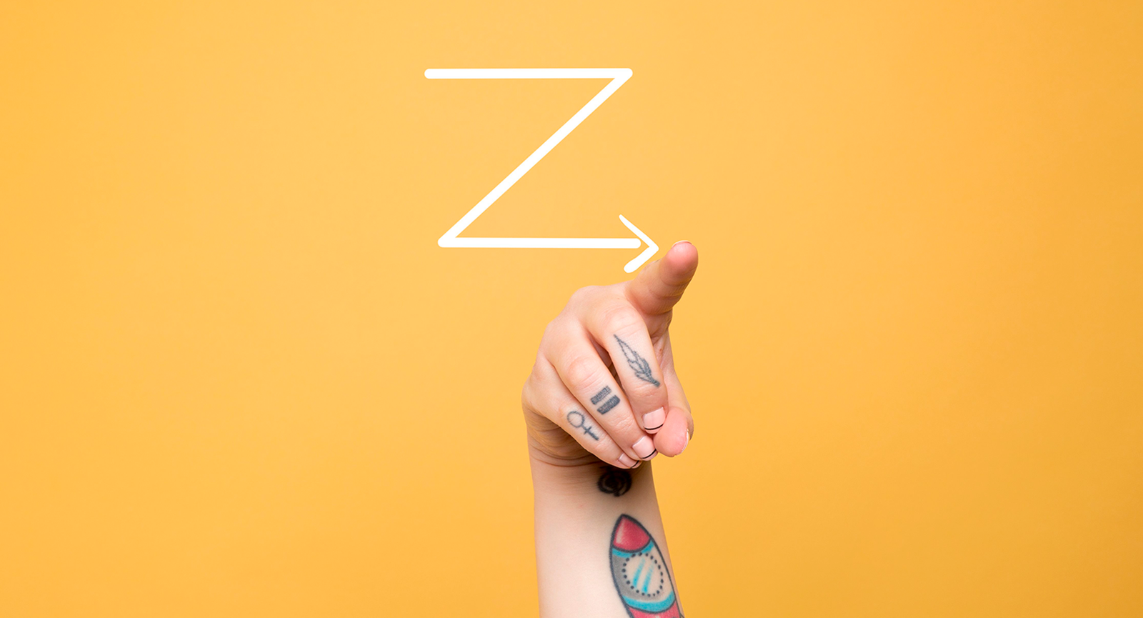 Bogstavet Z skrevet på karrygul baggrund og en arm med mange tatoveringer peger på enden af bagstavet