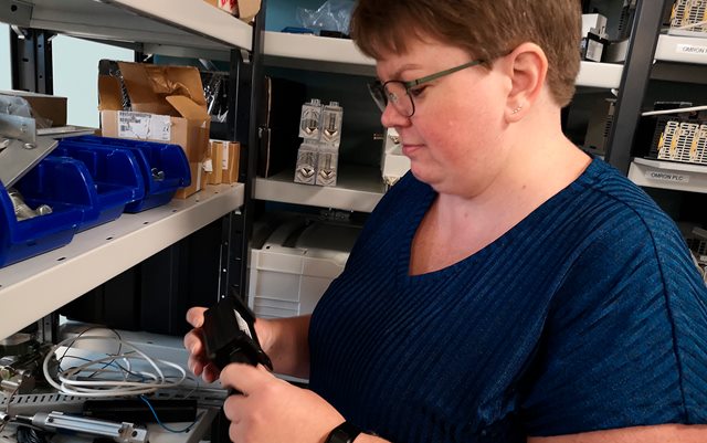 Automationsteknolog Pia kigger på en PLC i hænderne