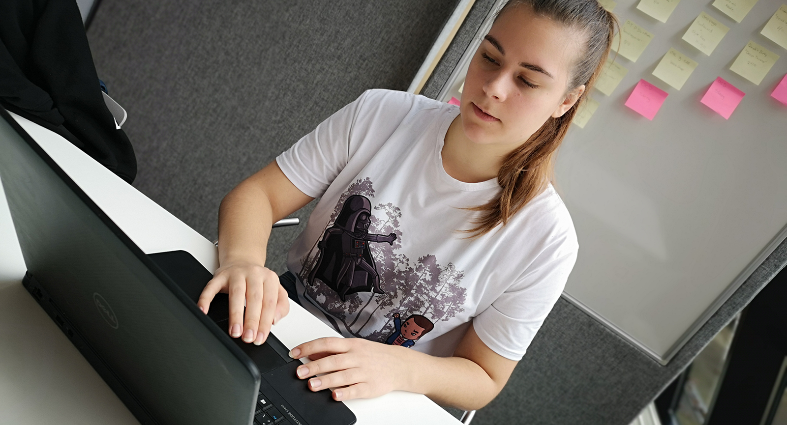 Datamatiker-studerende Helena Madsen sidder og arbejder på en bærbar computer.