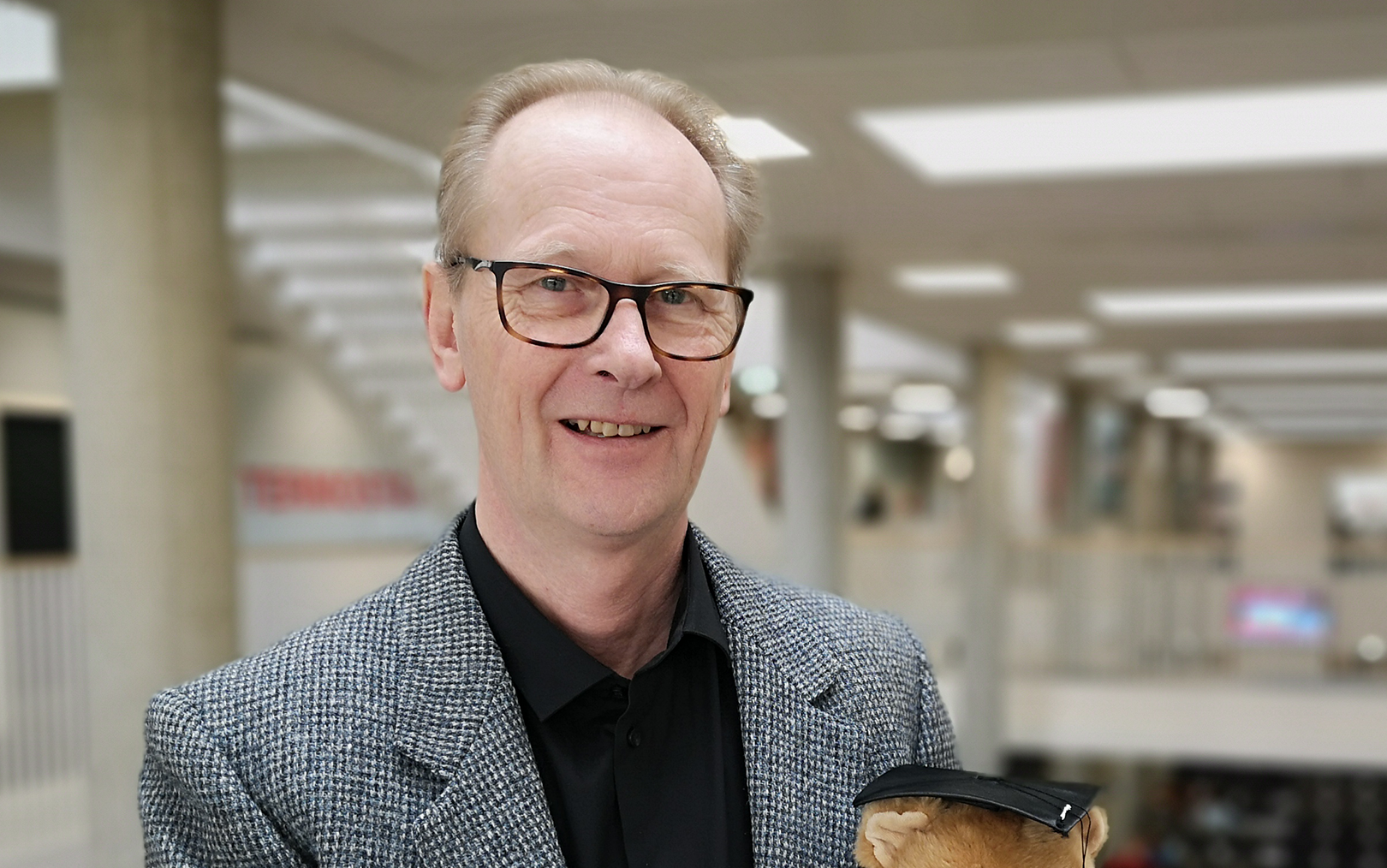 Nærbillede af underviser Thomas Mohr foran atriummet på Erhvervsakademi Dania.