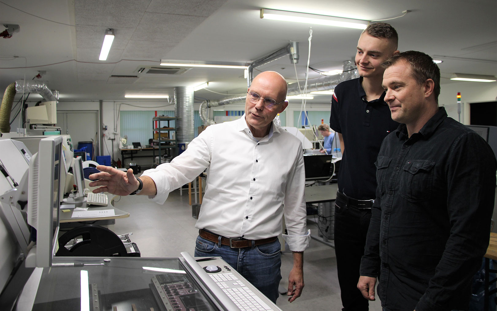 Ole Stabell viser nogle af de robotter frem, som Danotek har. Produktionsteknolog studerende Simon Jensen (midten) og Lars Bastrup er glade for samarbejdet og at prøve deres teori af i praksis på Erhvervsakademi Dania