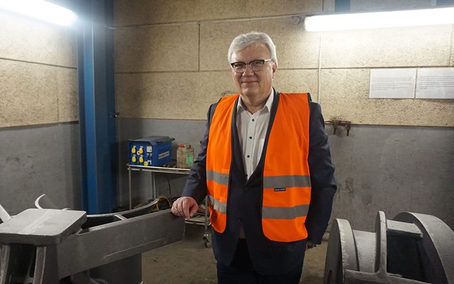 Thomas Riise, der har været på bestyrelsesuddannelse på Erhvervsakademi Dania, står i jakkeset og reflekvest ved store jernafstøbninger