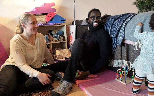 Hadji-Mary Cissé, der læser Marketing Management i Randers, sidder på gulvet hos sig selv sammen med kæresten Anne og datteren Ninna