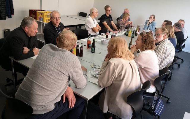 Familie, undervisere og dimittender sidder om langbord og hygger ved dimission for el-installatører