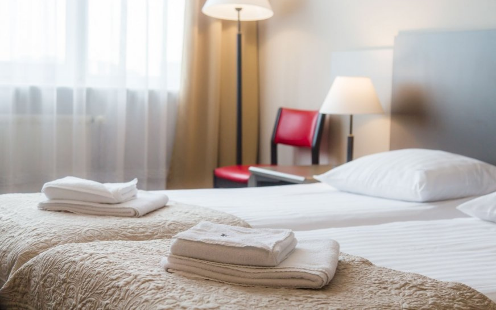 Hotel værelse i Polen med håndklæder liggende klar på den nyredte seng