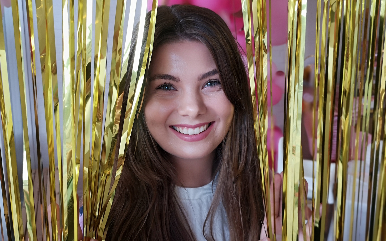 Markedsføringsøkonom Karoline Holmbroe kigger ud fra et guldglimmergardin