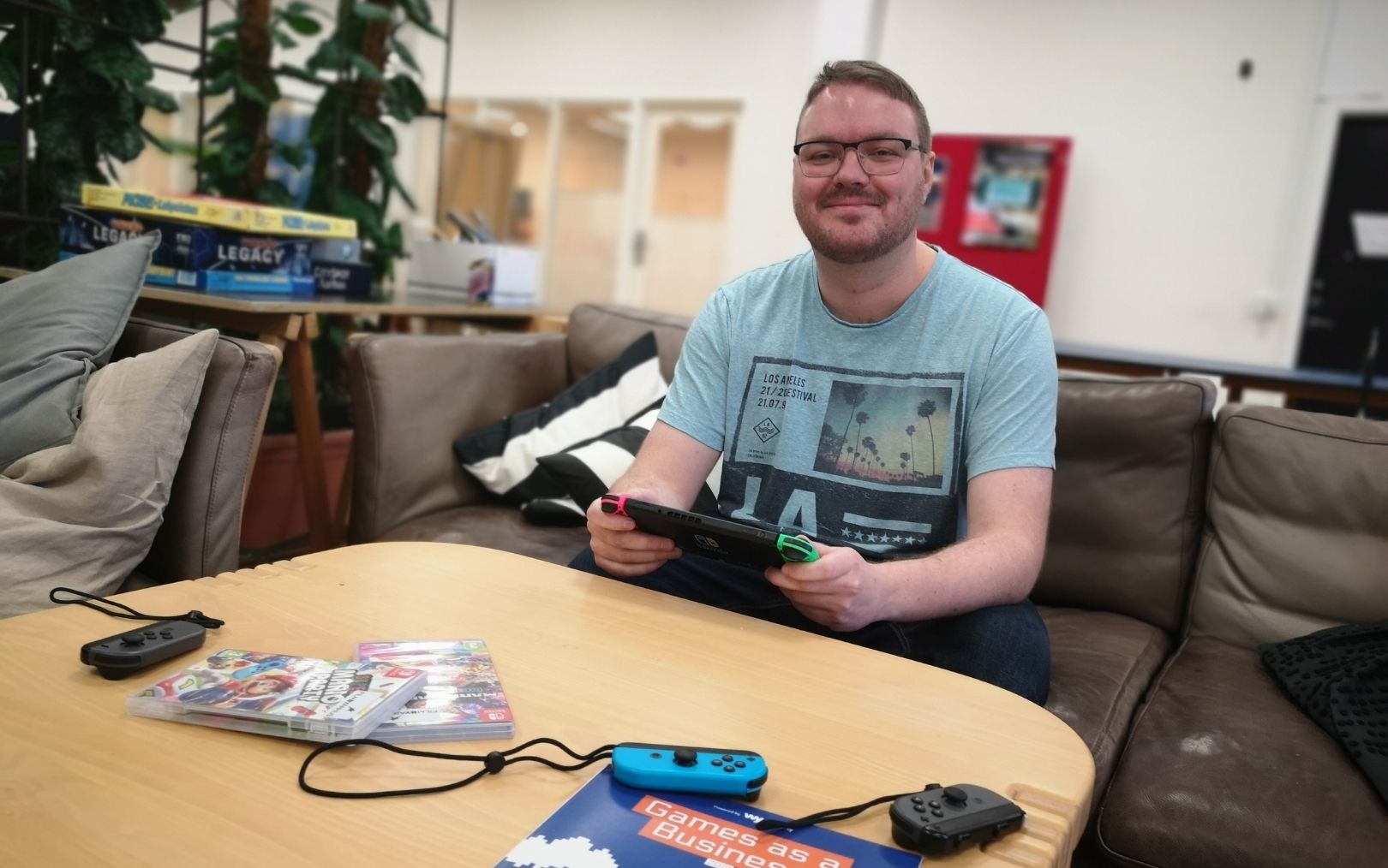 Jonas sidder med spilkonsol i sofa og kigger på dig