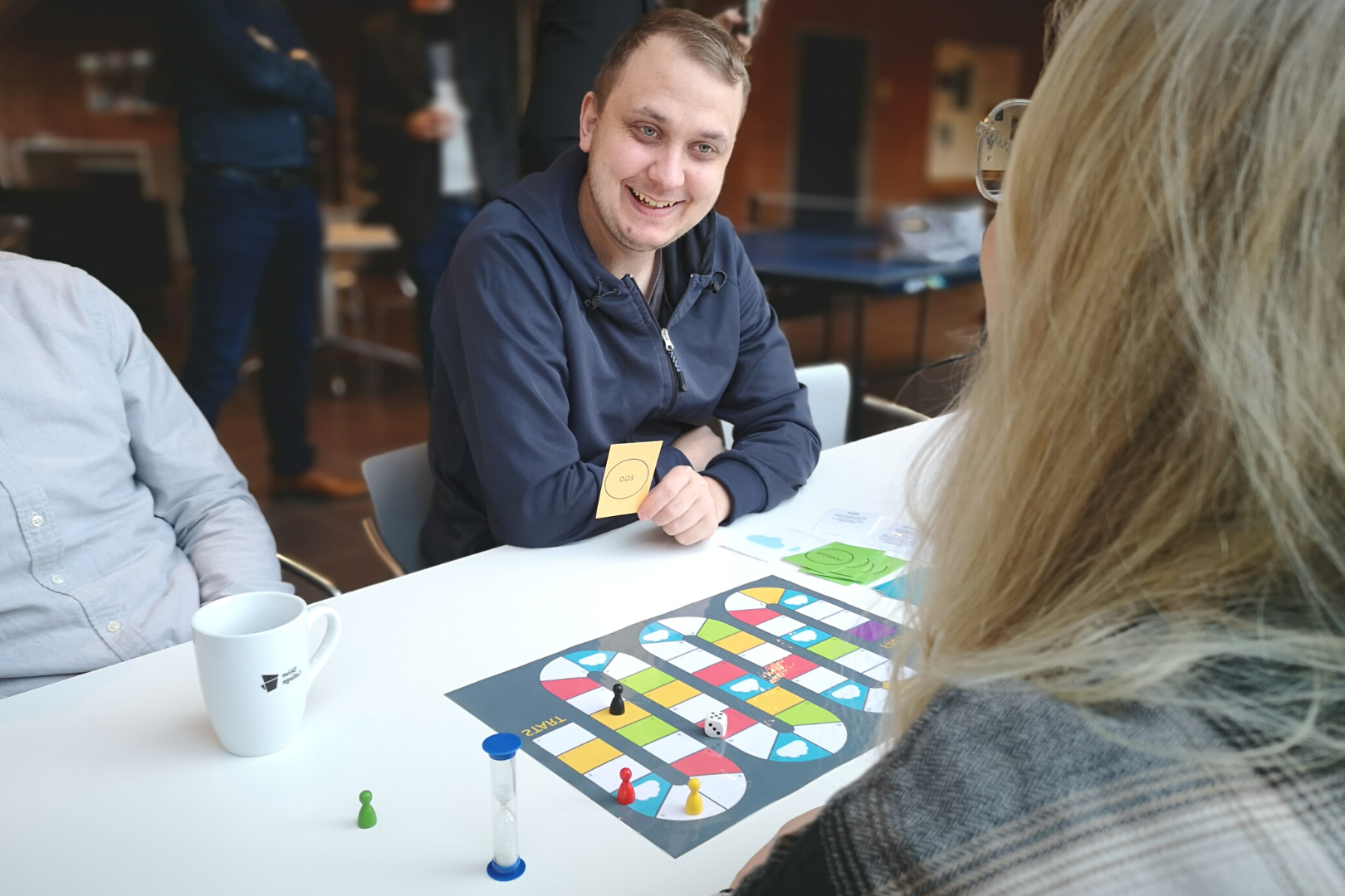 E-handels studerende i Skive spiller refleksionsspil og smiler til en kvindelig medstuderende med et kort i hånden