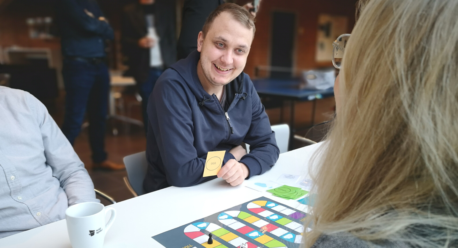 E-handels studerende i Skive spiller refleksionsspil og smiler til en kvindelig medstuderende med et kort i hånden