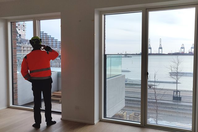 El-installatør studerende Michael Salling taler i telefon og kigger ud af vinduet i en lejlighed på Aarhus Ø
