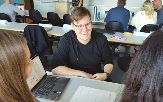 Jakob griner, mens han har gruppearbejde på studiet til dataanalytiker på Erhvervsakademi Dania