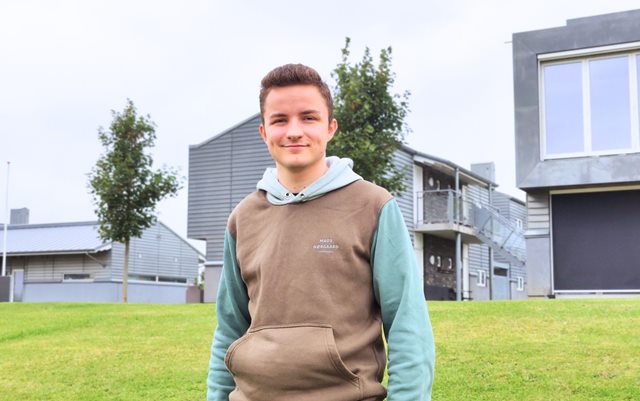 Frederik, der læser til el-installatør på Erhvervsakademi Dania i Randers, står foran de studieboliger, han dag selv bor i