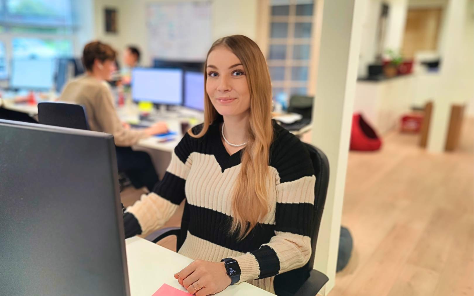 Zenia, der læser til handelsøkonom, sidder ved son computer på kontoret ved Cotonshoppen og smiler til dig