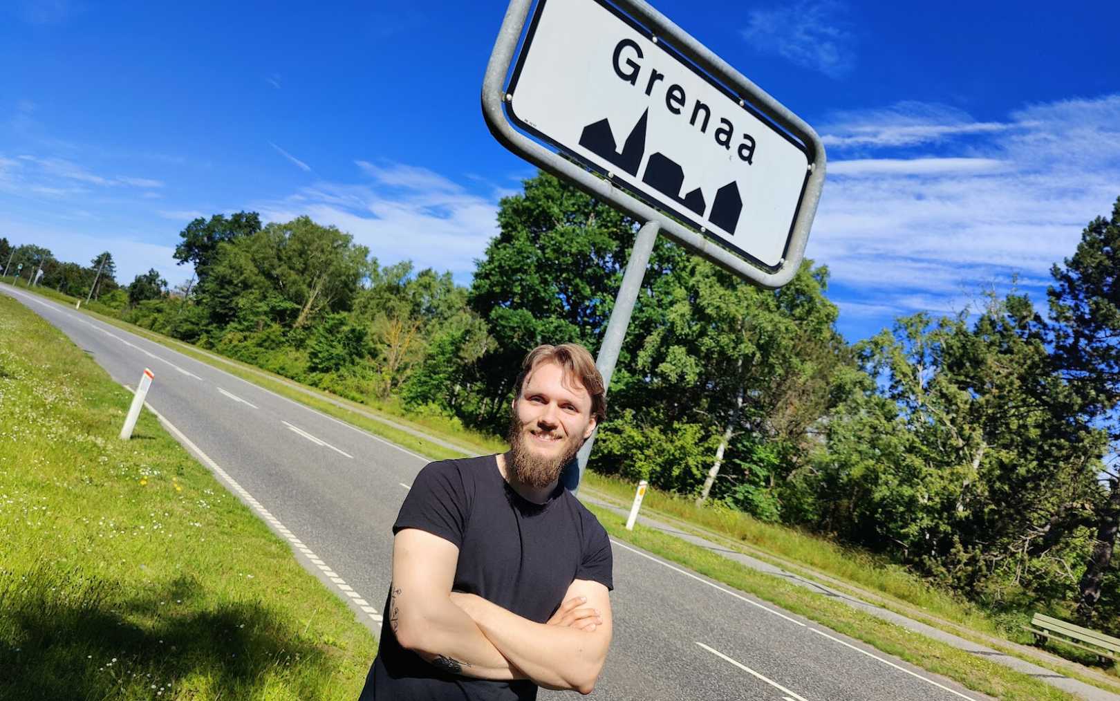 24-årige Andreas Hendriksen læner sig op ad byskiltet til Grenaa, hvor han er flyttet til for at læse til spiludvikler på Erhvervsakademi Dania 