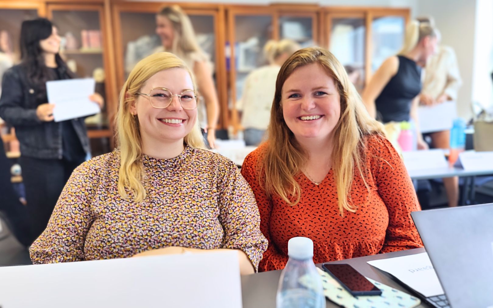 Sissel Hansen og Anne Elgaard smiler til dig i en klasse fuld af studerende til optiker kaldet optometrist ved Erhvervsakademi Dania