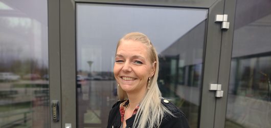 Heidi, der har læst på erhvervsakademi dania, står foran døren til campus i Silkeborg