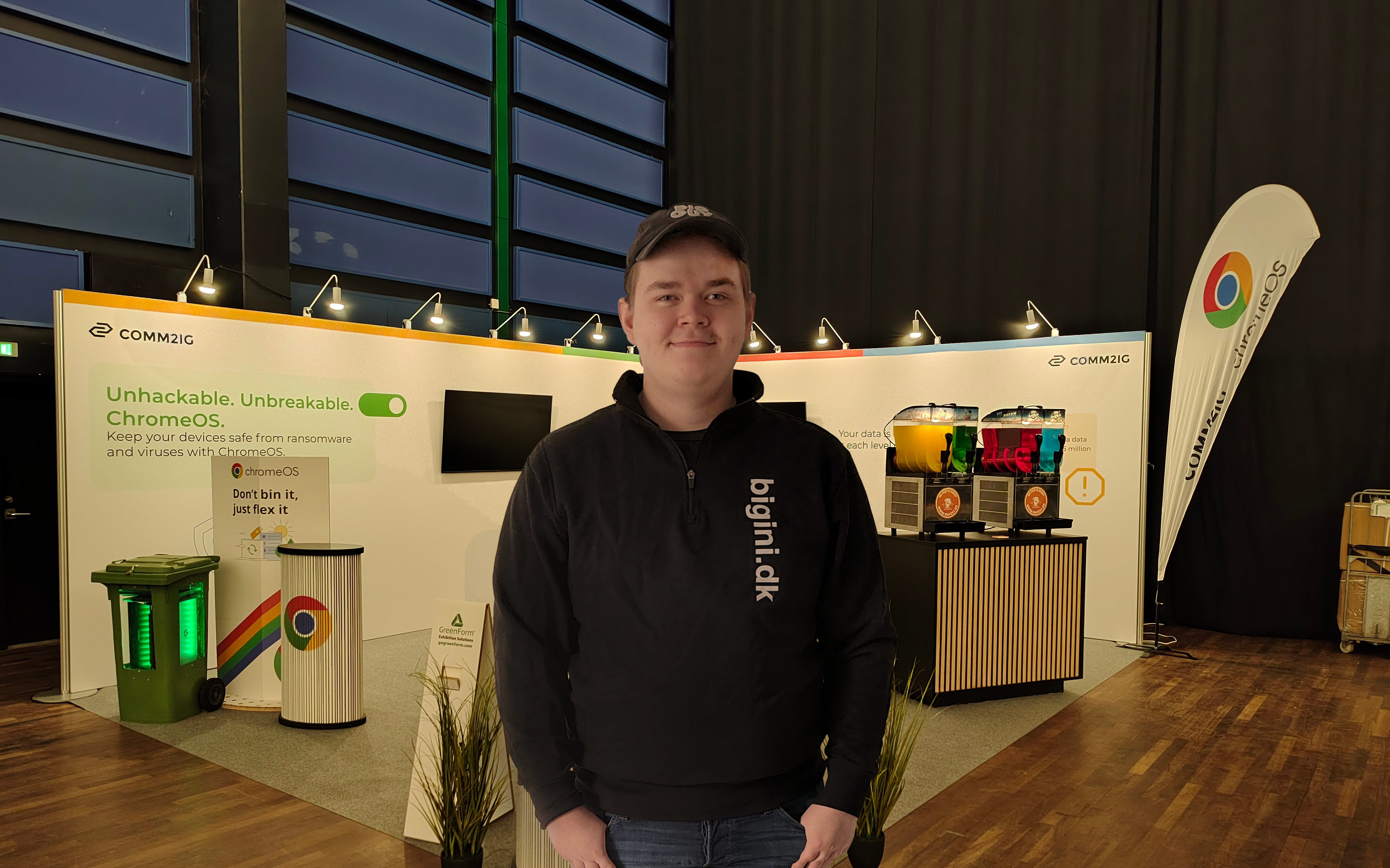 Studerende står foran en messestand med et stort smil i ansigtet