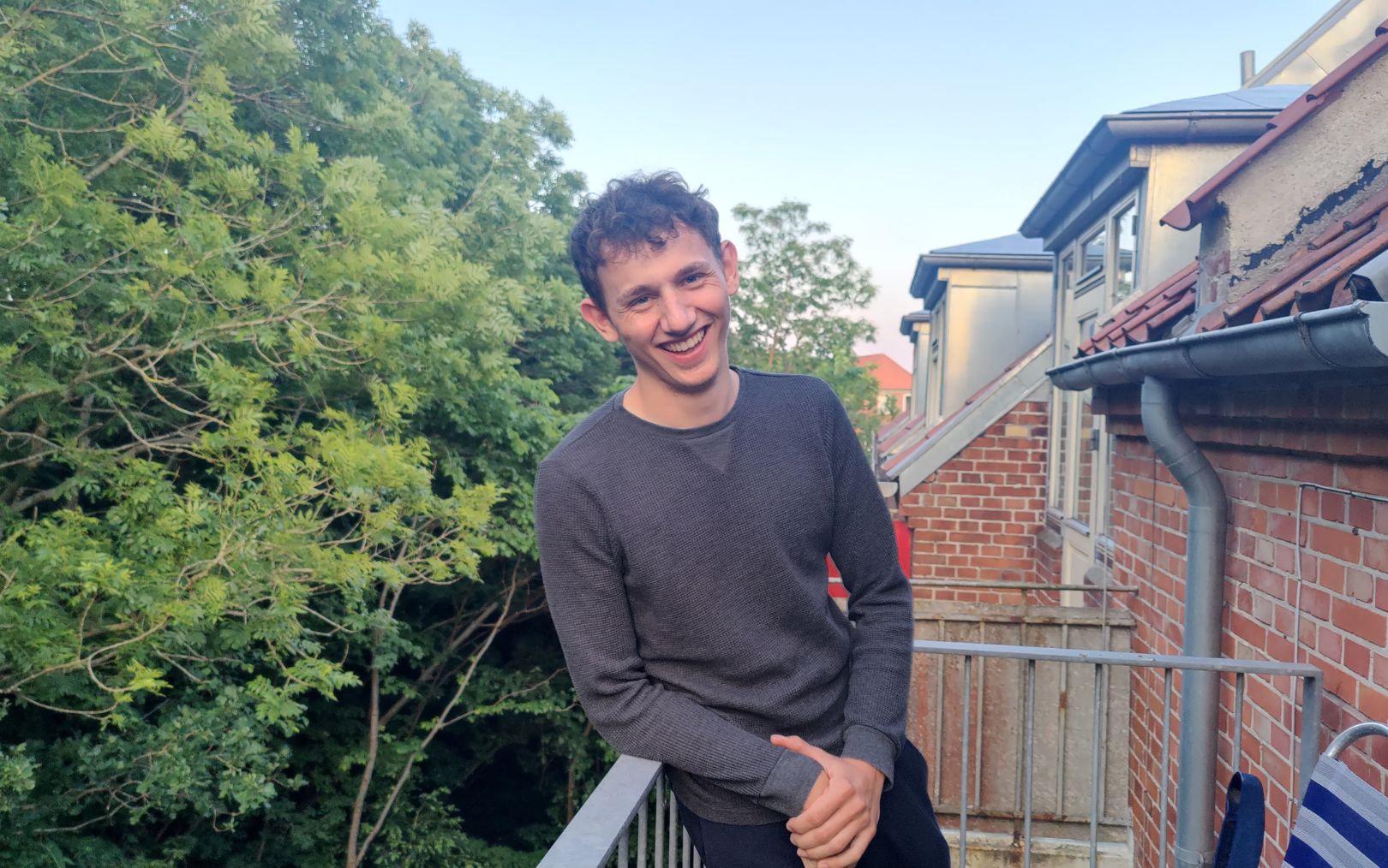 Thor Christensen, der har søgt ind på studiet til automationsteknolog, står på sin terrasse og smiler 