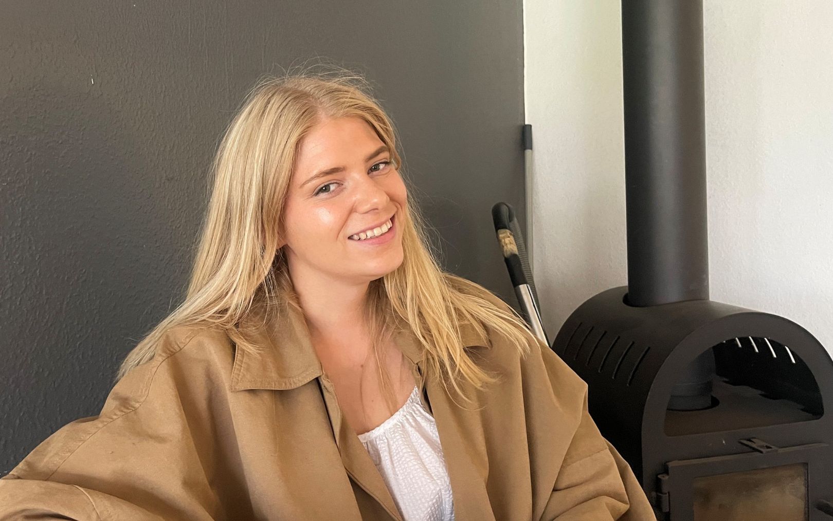Louise Ulrik Haparanda, der har søgt ind som handelsøkonom på Erhvervsakademi Dania, sidder i sin sofa med brændeovnen i baggrunden