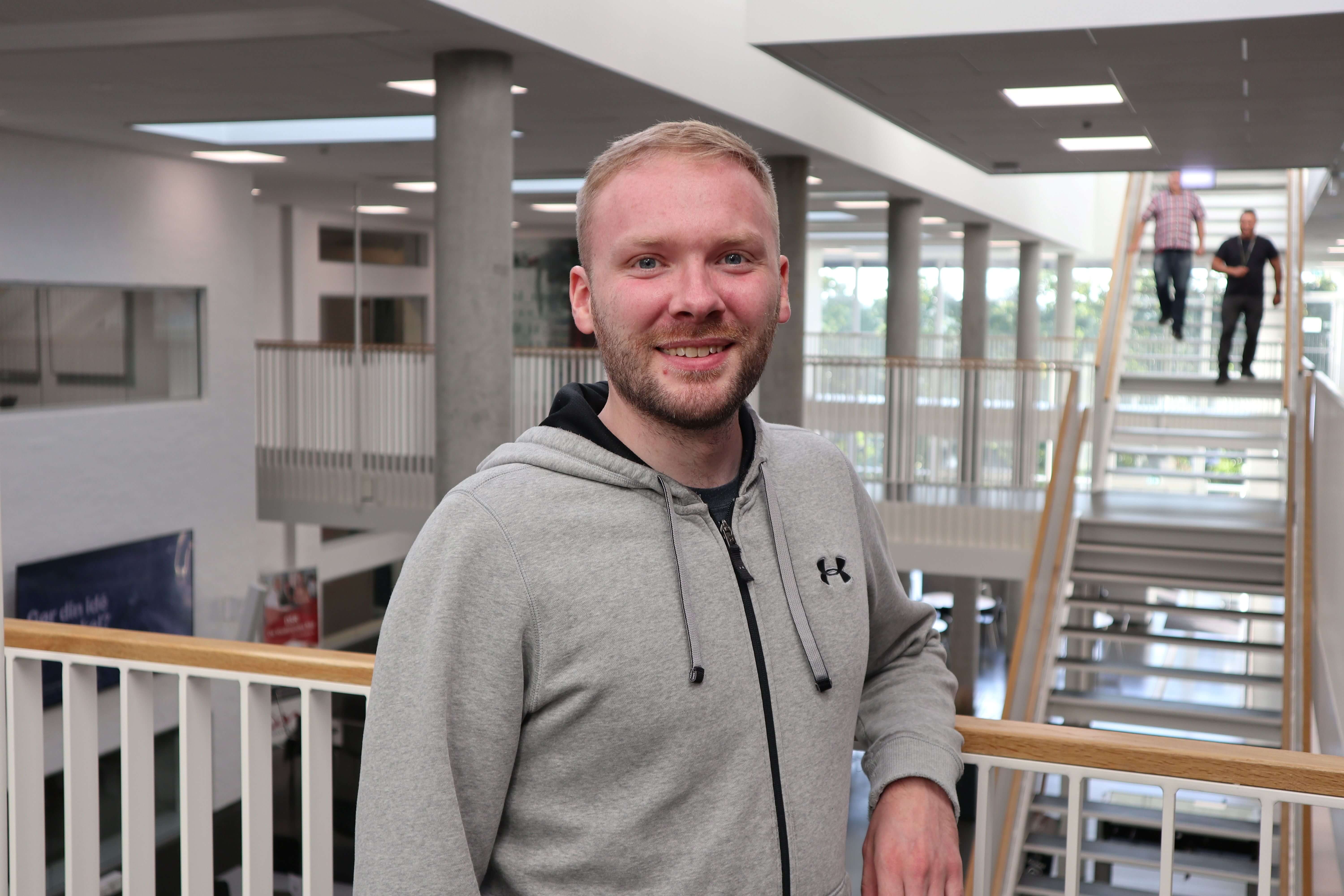 Thomas Bak står foran trapperne på Campus Randers og smiler
