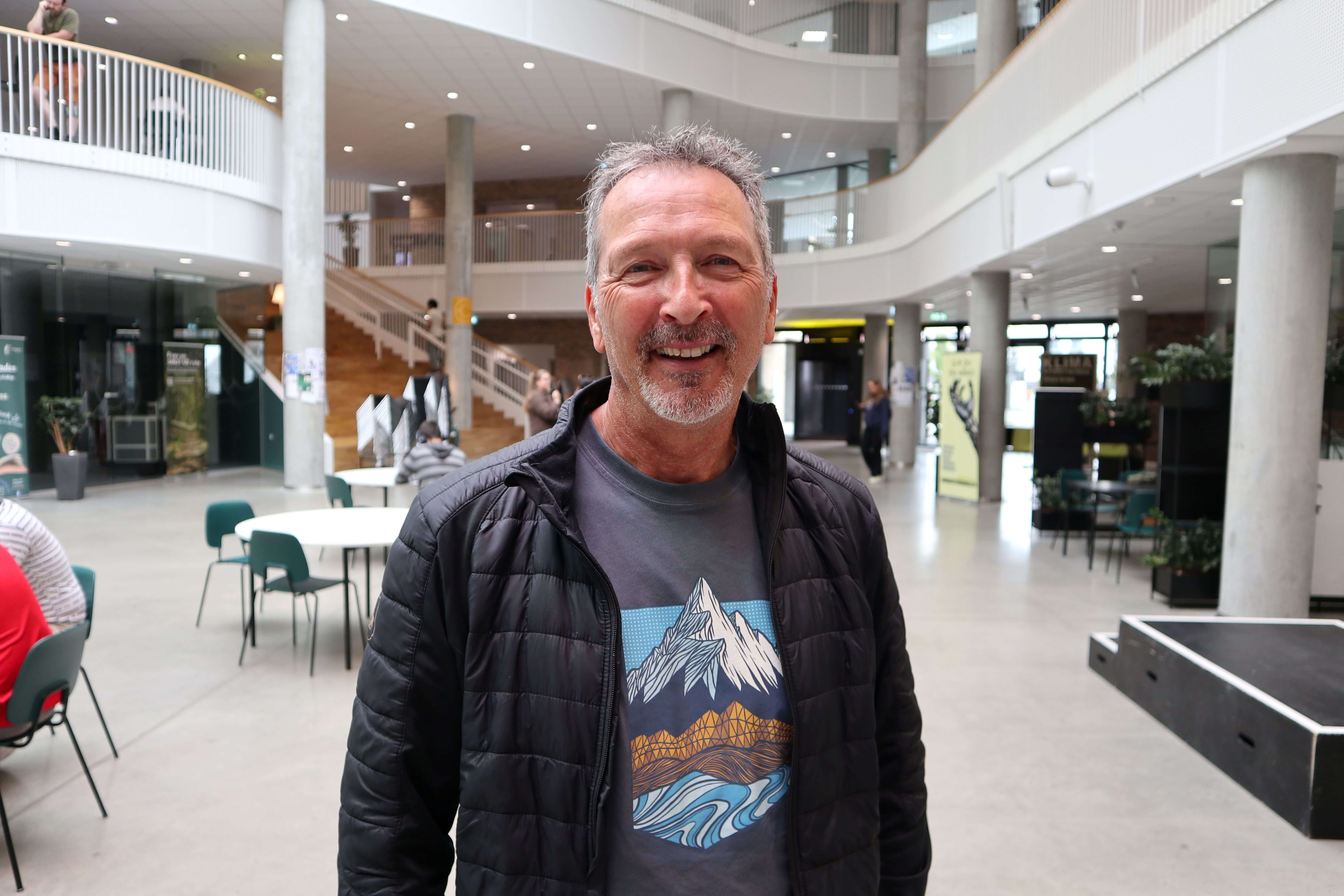 Kim Mandor Faarkrog Christensen står i kantinen på campus Horsens med et smil