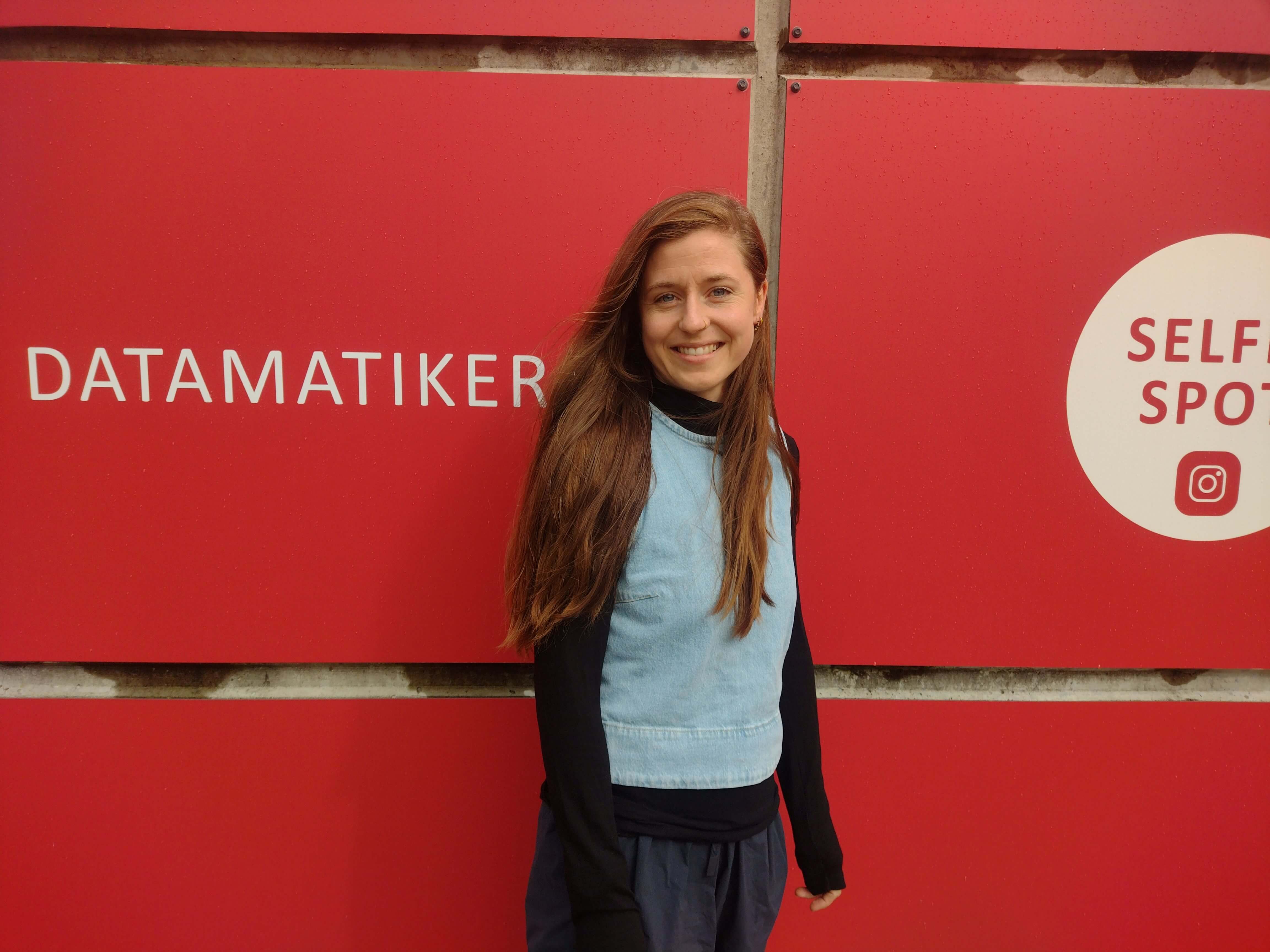 Anna Vognstoft står foran campus Silkeborg med et stort smil